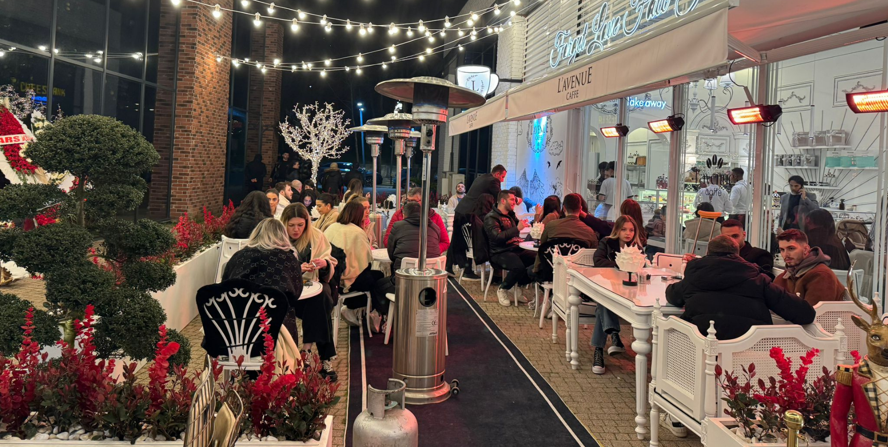 Süslemeli kafe terasında sıra halinde dış mekân ısıtıcıları