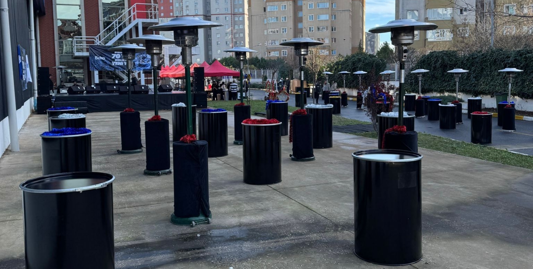 Geniş bir plaza alanında sıralanmış çok sayıda dış mekân ısıtıcısı