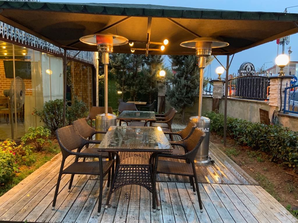 Pergola altındaki oturma alanını ısıtan dış mekân gazlı ısıtıcı